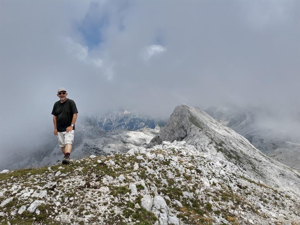mężczyzna w sportowym ubiorze stoi na szczycie góry