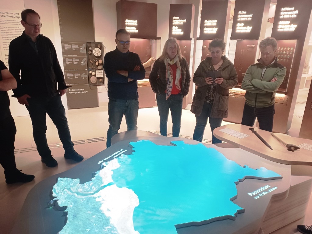 grupa ludzi stojących w muzeum nad jednym z eksponatów