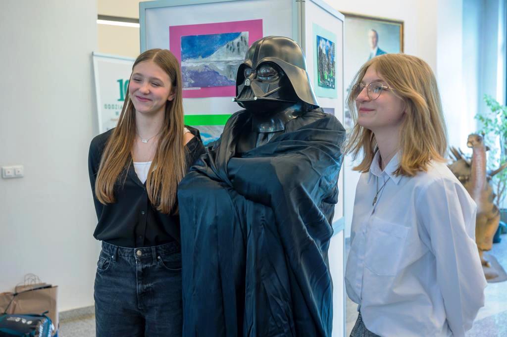 trzy osoby pozujące do zdjęcia, jedna w stroju Lorda Vadera