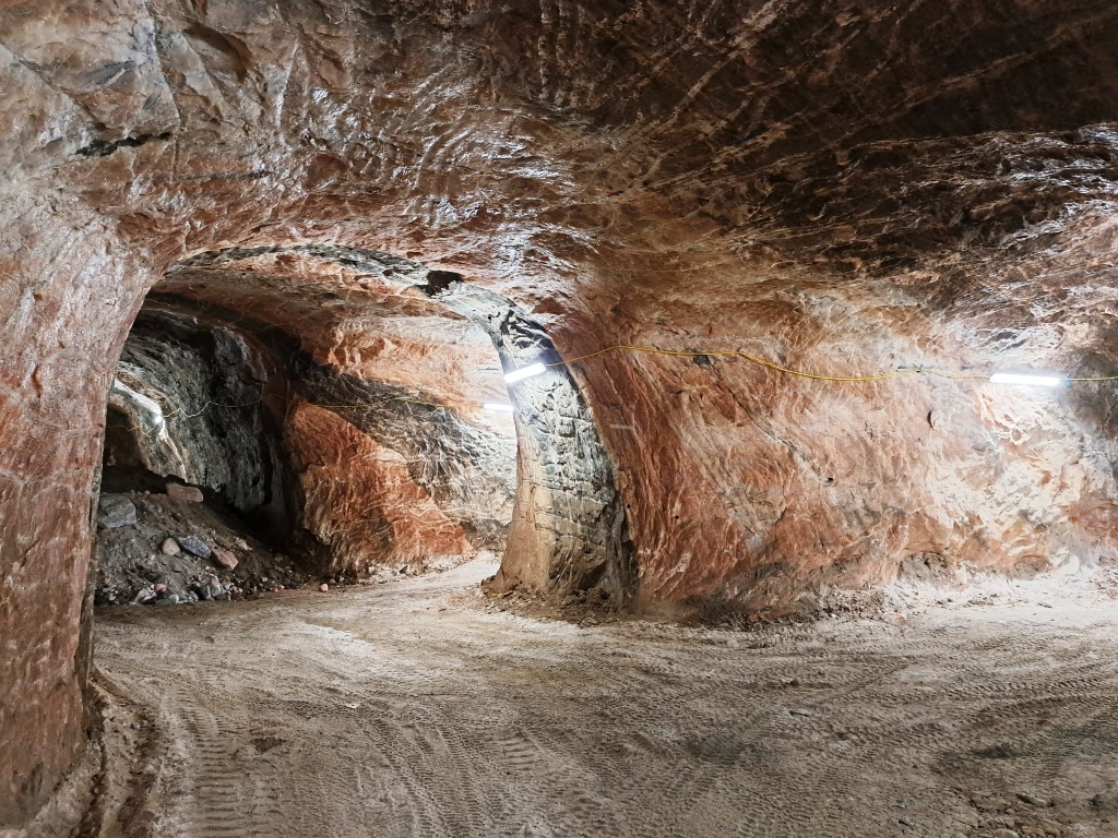 wnetrze kopalni soli, w lewej cześci widoczny fragment korytarza, na ścianach wyrobiska znajduje się różowa sól
