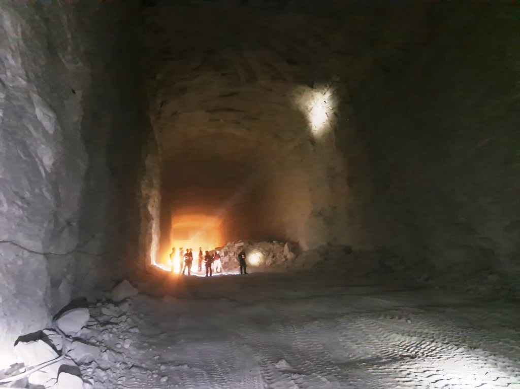 ogromna komora wyrobiska we wnętrzu kopalni soli, w tle widać grupę osób