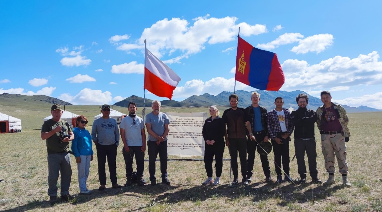 grupa osób pozujących do zdjęcia w mongolskim stepie, z flagami polską i mongolską