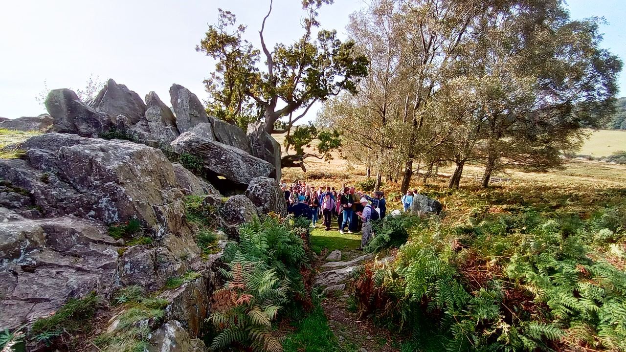 grupka osób w terenie obok skalnej formacji