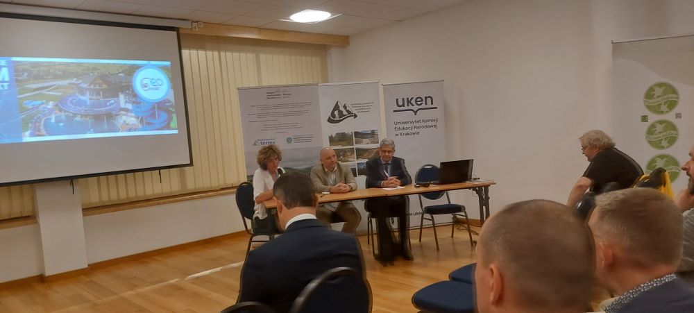 kilka osób siedzących za stołem w dużej sali