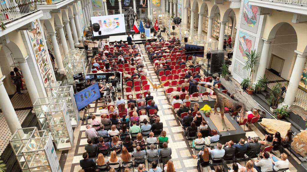 sala muzealna pełna ludzi siedzących na krzesłach podczas uroczystości jubileuszowych