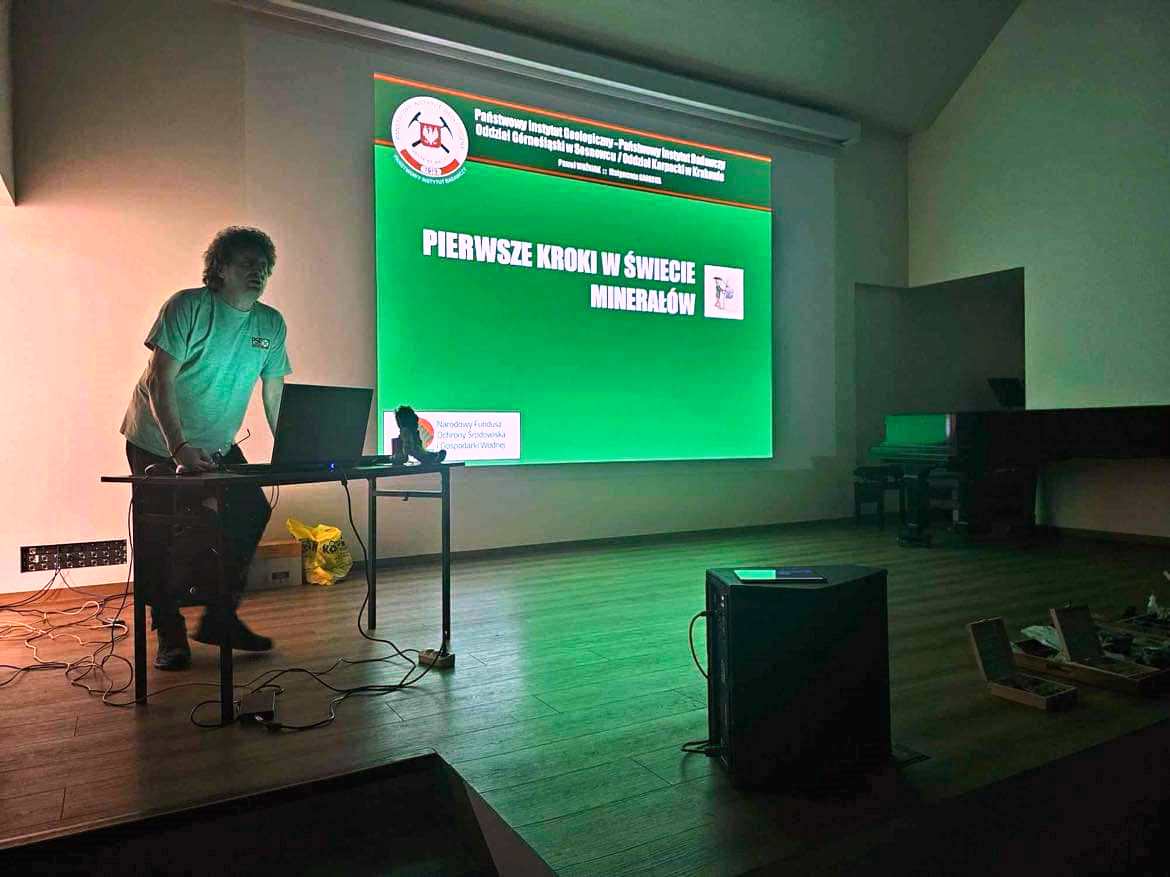 mężczyzna pokazuje prezentacje na dużym ekranie w zielonej poświacie