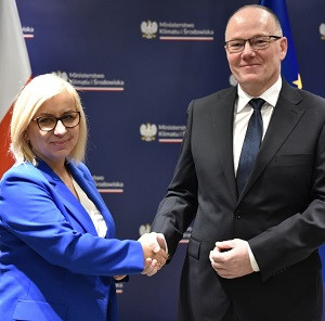 kobieta w niebieskiej garsonce gratuluje mężczyźnie w garniturze 