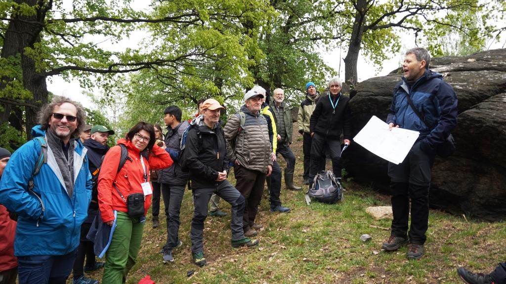 grupa osób ubranych terenowo podczas wycieczki geologicznej