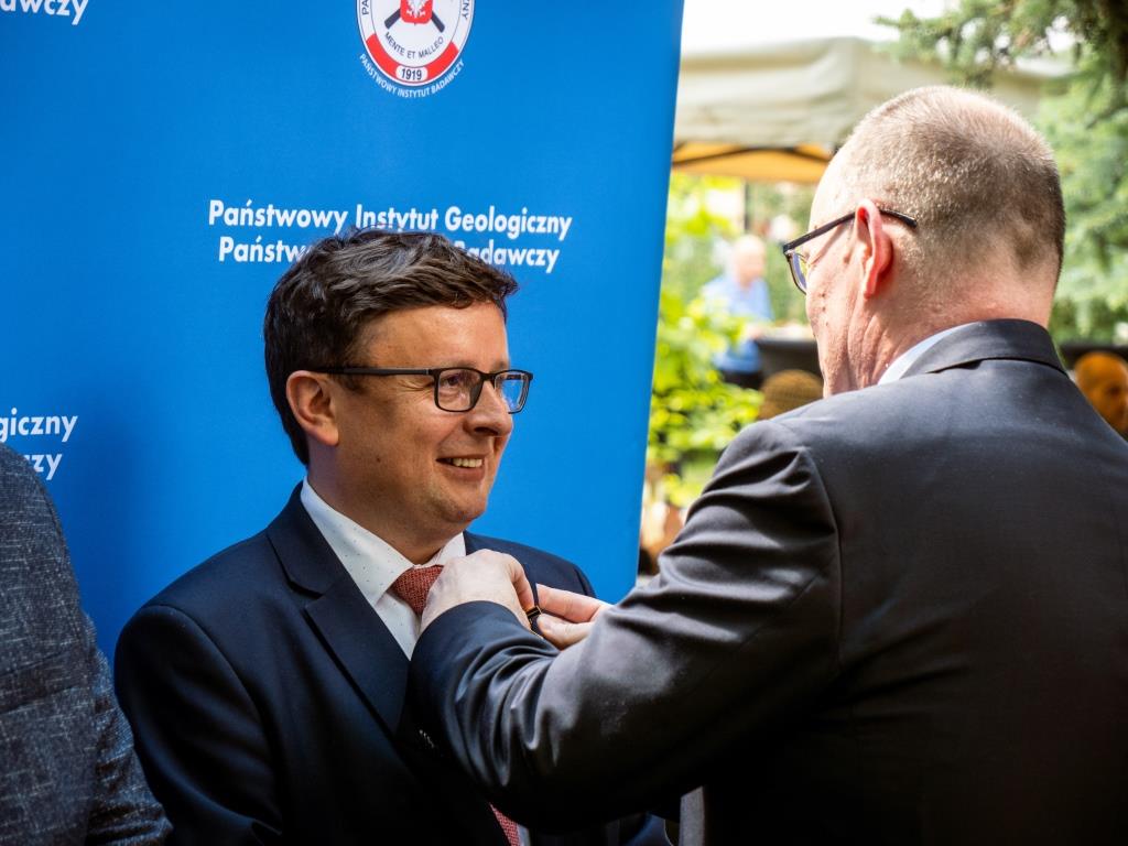 mężczyzna odznacza innego mężczyznę medalem