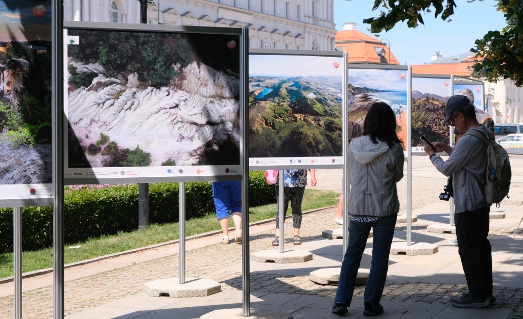 osoby oglądające plansze wystawy plenerowej