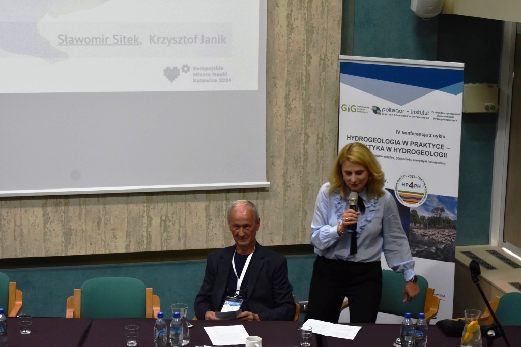 kobieta przemawia na tle ekranu z prezentacją