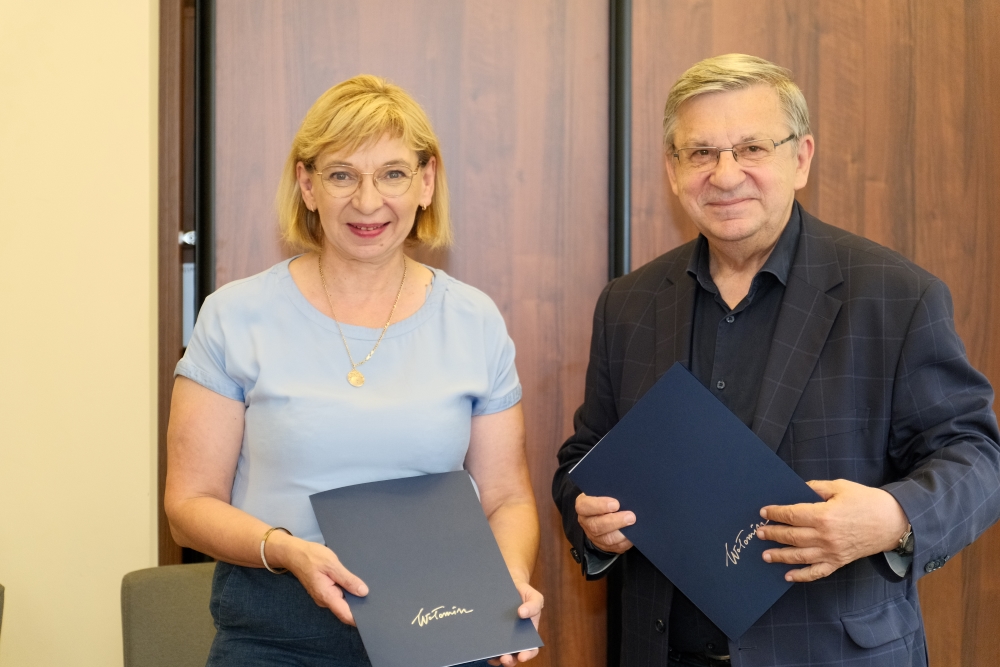 kobieta i mężczyzna pozują do zdjęcia, trzymając w dłoniach podpisane umowy
