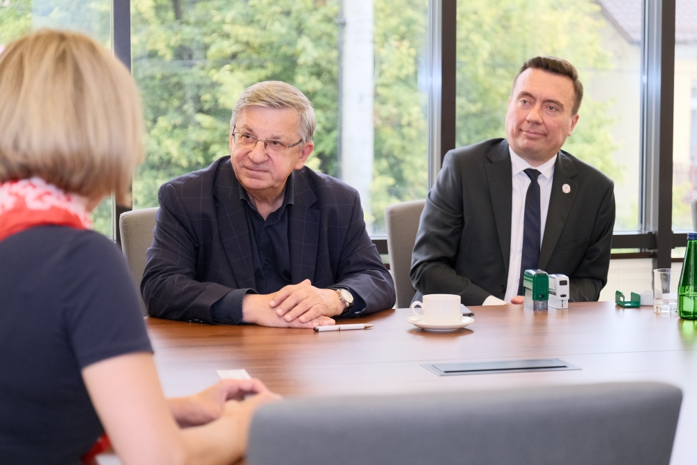 kilka osób siedzących i rozmawiających przy stole