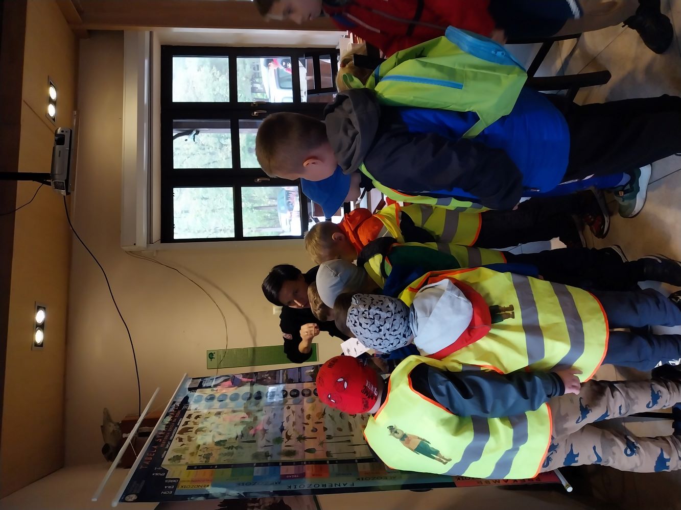 grupa dzieci zgromadzonych wokół stoiska edukacyjnego