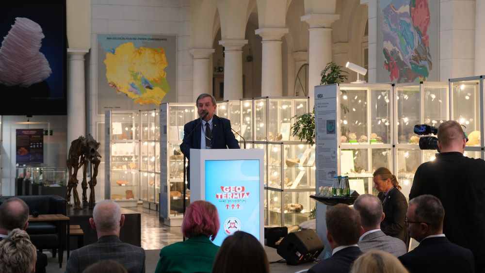 mężczyzna na mównicy w sali muzealnej 