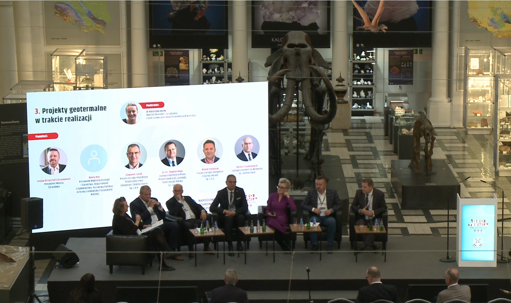 panel dyskusyjny z kilkoma uczestnikami w sali muzealnej