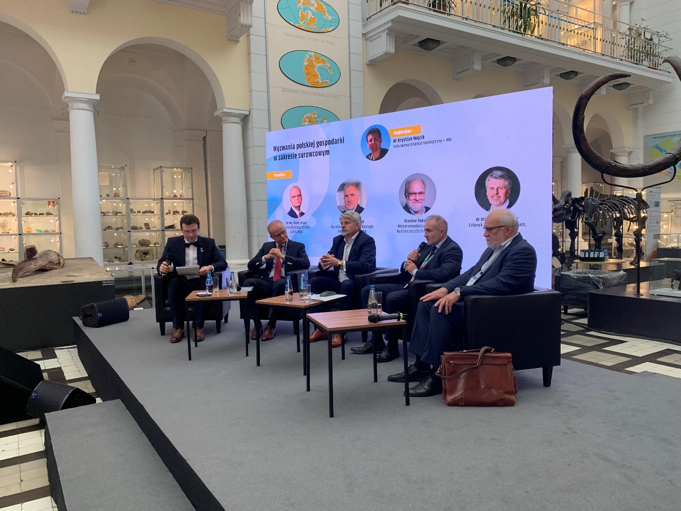 panel dyskusyjny z kilkoma uczestnikami w sali muzealnej