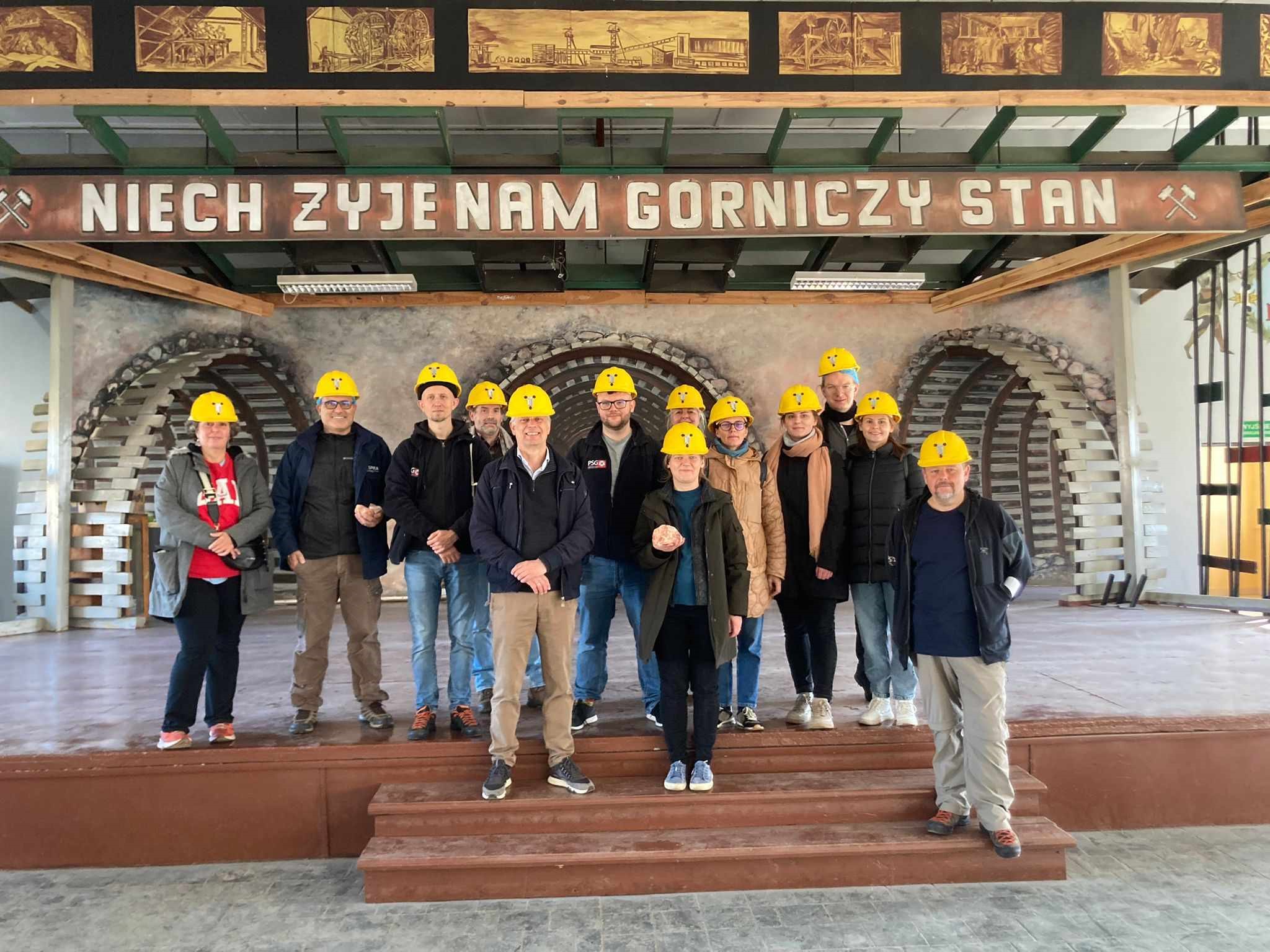 grupa osób pozuje do zdjęcia w kaskach