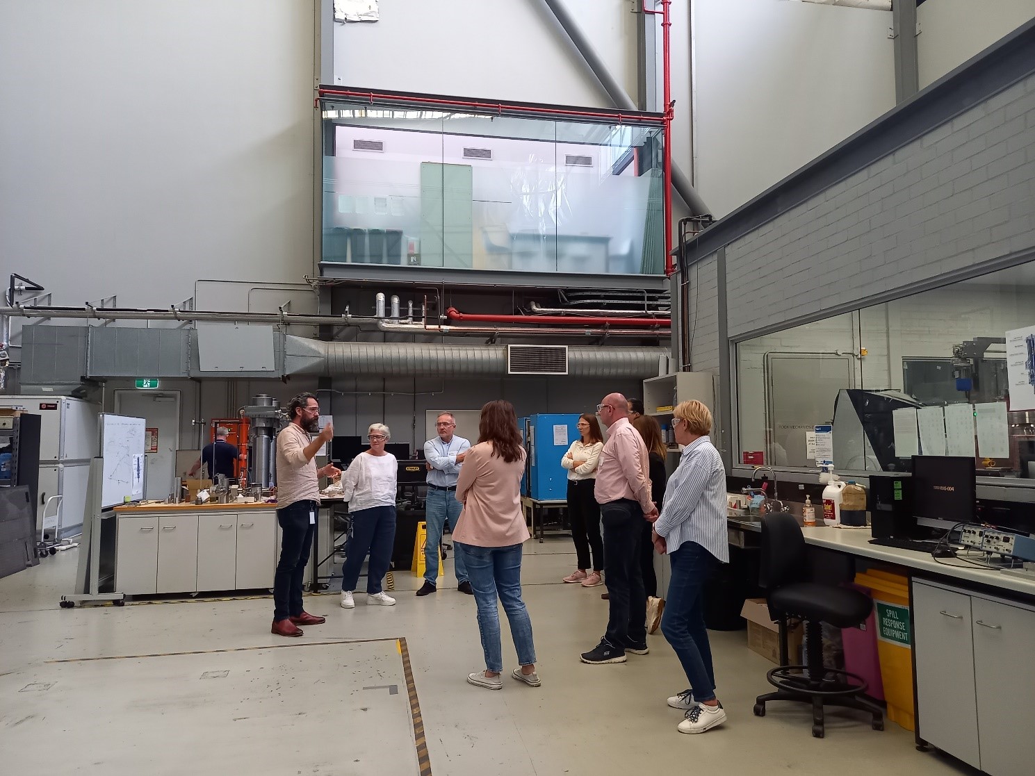 grupa ludzi w laboratorium rozmawia ze sobą