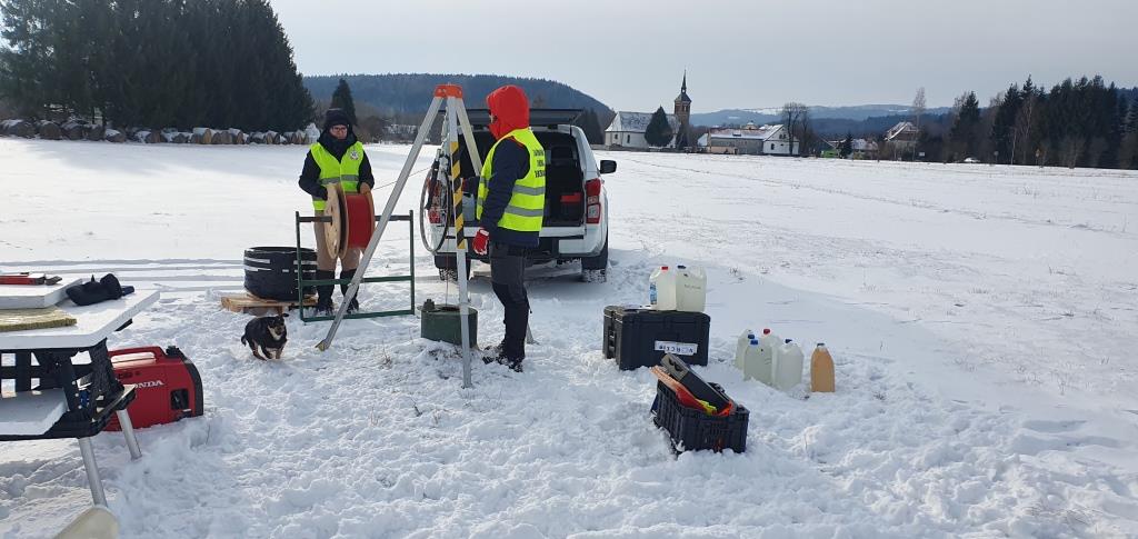 dwóch ludzi prowadzi prace terenowe na polu pokrytym sniegiem