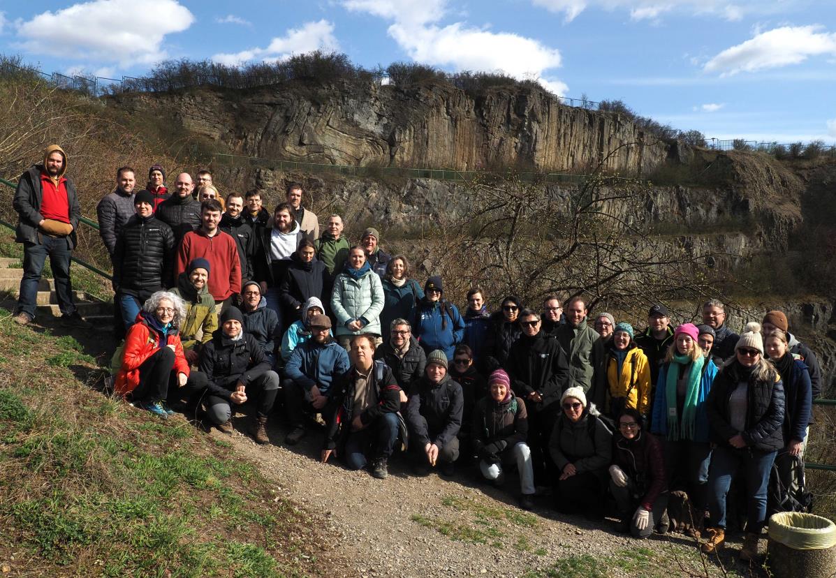 grupa osób pozujących do zdjęcia na tle formacji geologicznej
