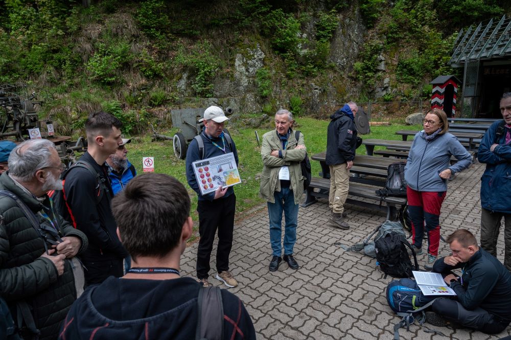 dwóch mężczyzn tłumaczy kwestie geologiczne uczestnikom wycieczki terenowej