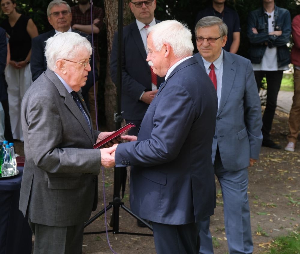 mężczyzna wręcza odznaczenia