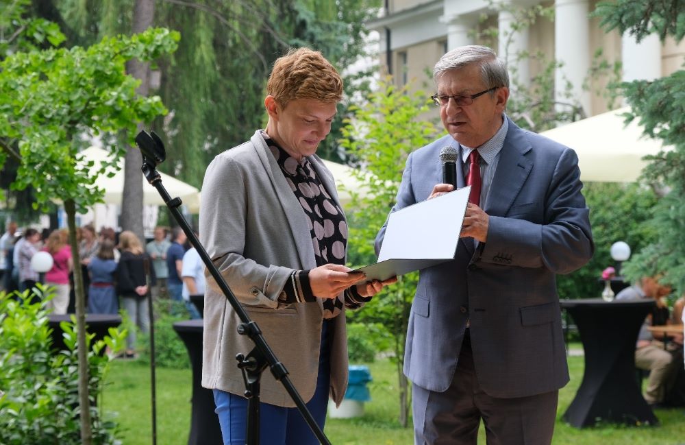mężczyzna wręcza kobiecie list okolicznościowy