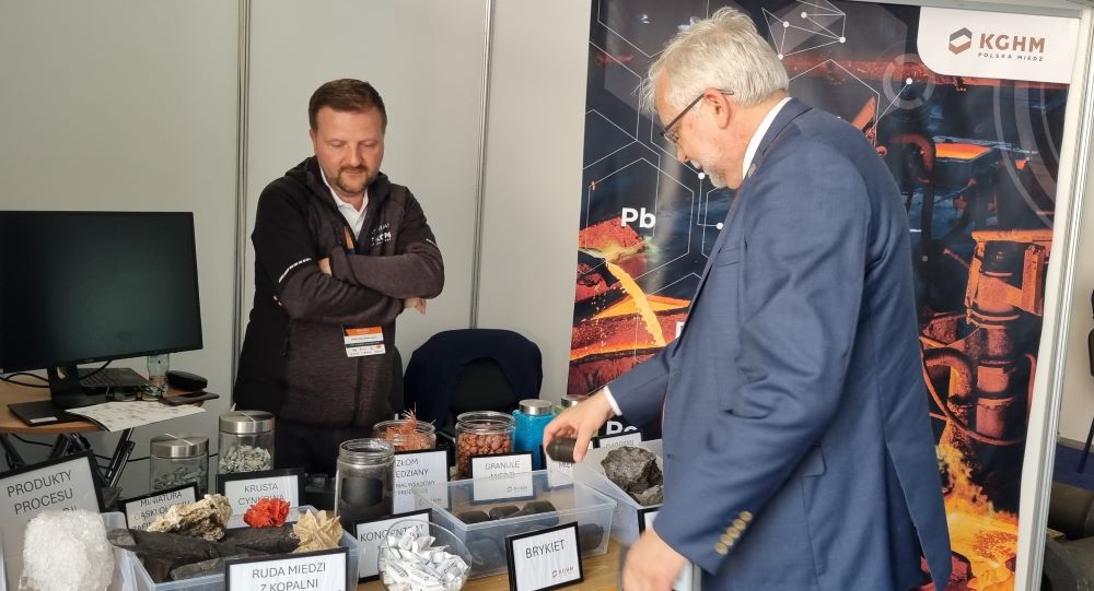 stoisko promocyjne i mężczyzna w garniturze oglądający okazy skał