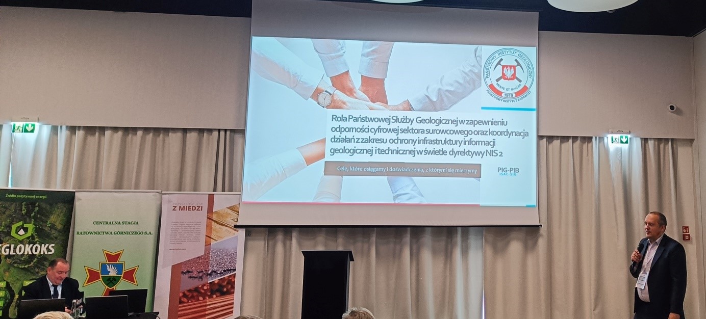 mężczyzna przemawia do siedzącej w pomieszczeniu publiczności