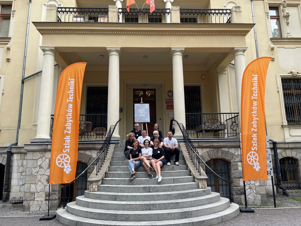 grupa ludzi siedzących na schodach pozuje do zdjęcia