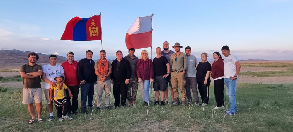 grupa ludzi pozujących do zdjęcia na mongolskim stepie