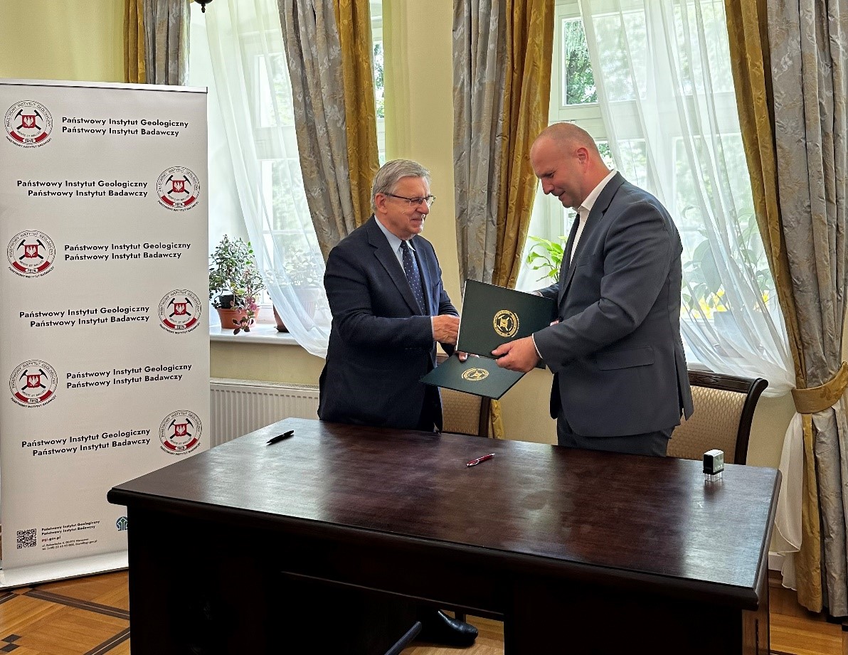 dwóch mężczyzn wymienia sie egzemplarzami podpisanych umów