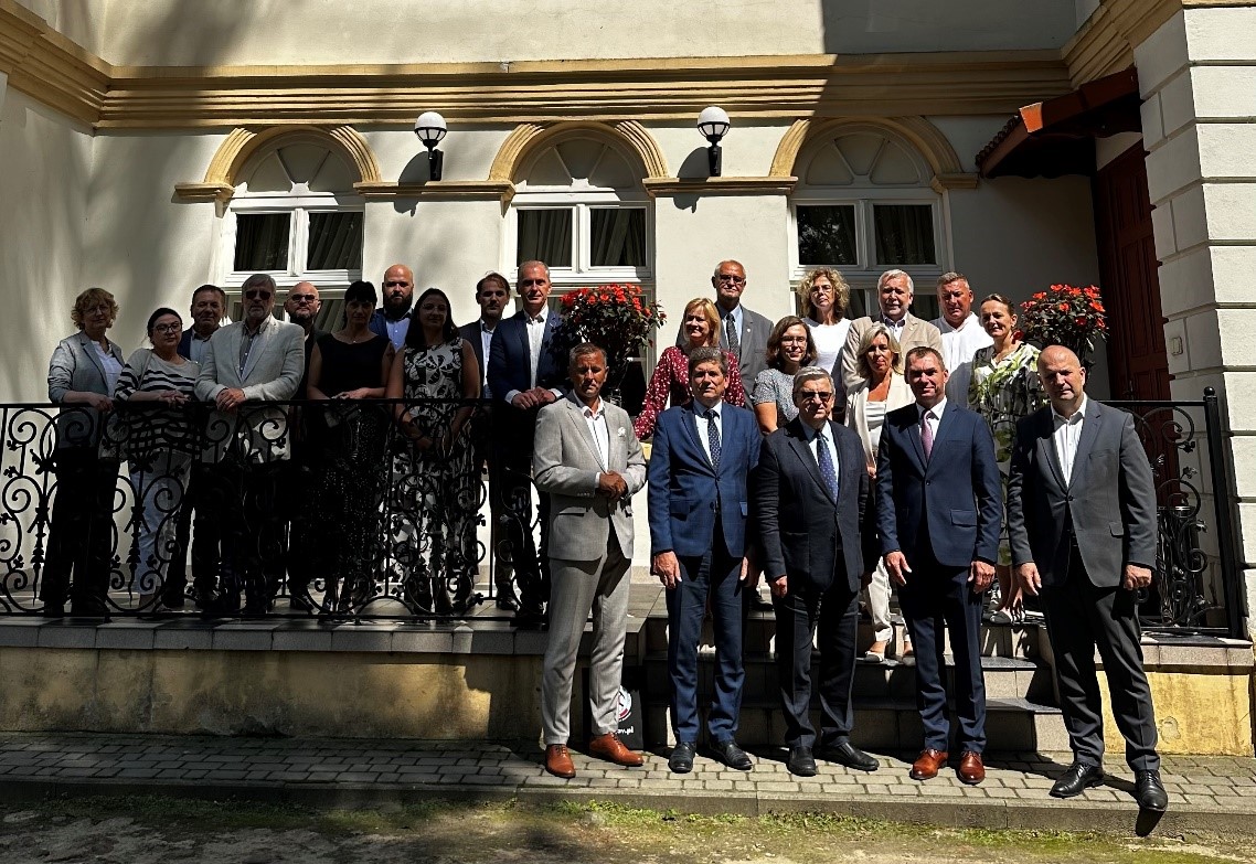 grupa ludzi pozujących do zdjęcia na zewnątrz
