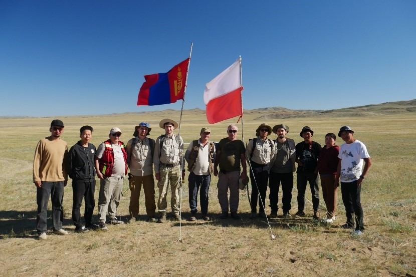 grupa ludzi pozuje do zdjęcia na stepie w Mongolii