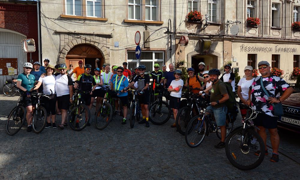 grupa osób na rowerach pozuje do zdjęcia
