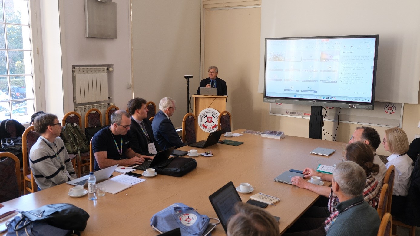 mężczyzna przemawia do siedzącej w pomieszczeniu publiczności