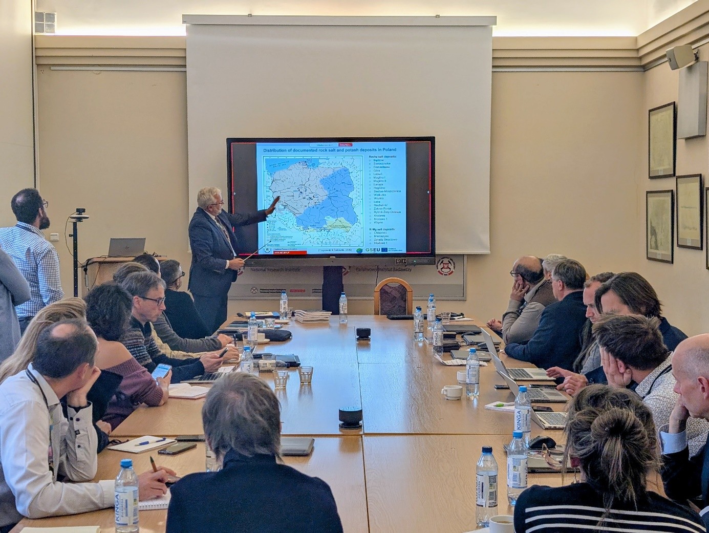 mężczyzna tłumaczy uczestnikom spotkania kwestie na mapie