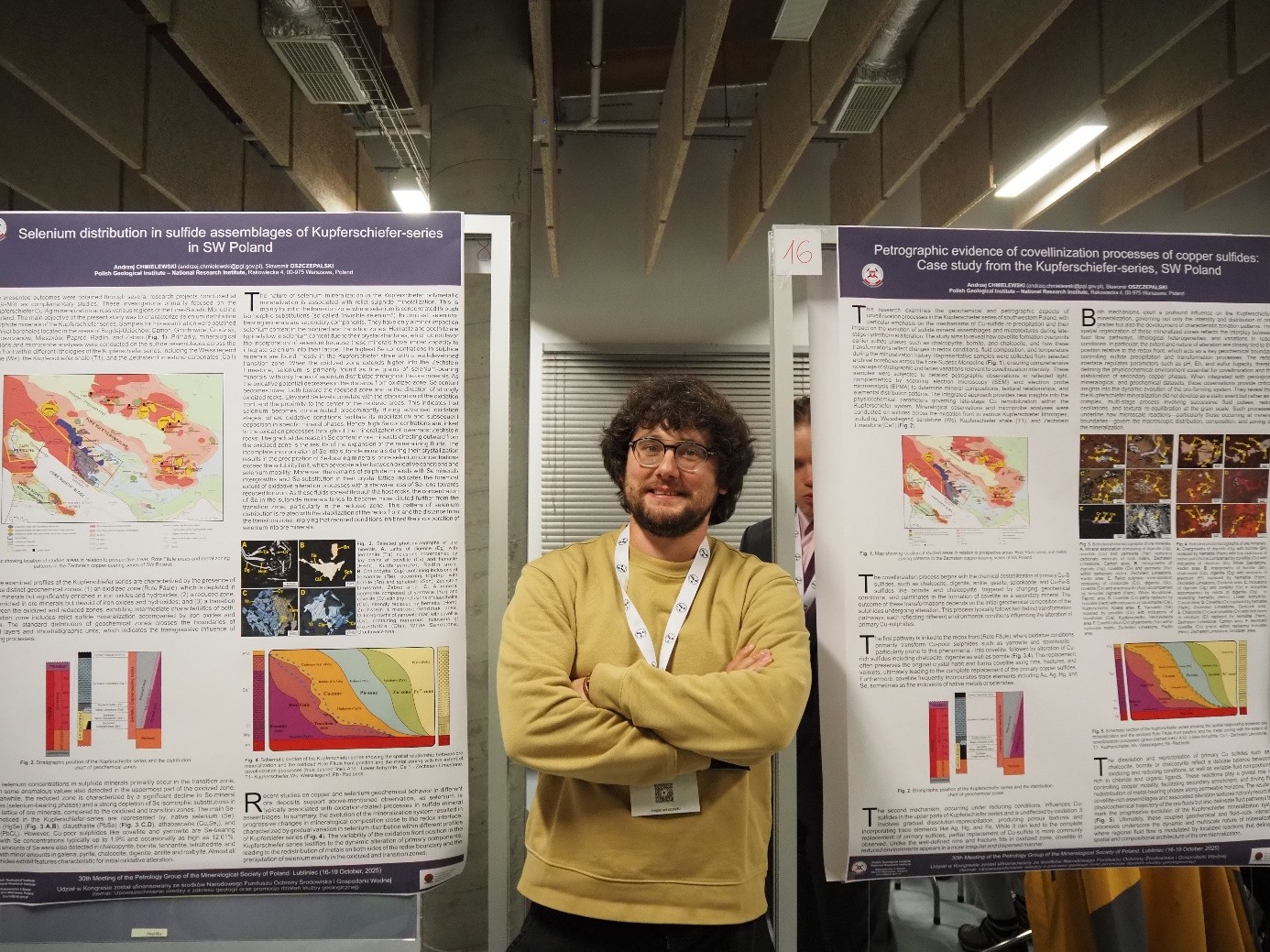 mężczyzna pozuje do zdjęcia na tle posterów z konferencji