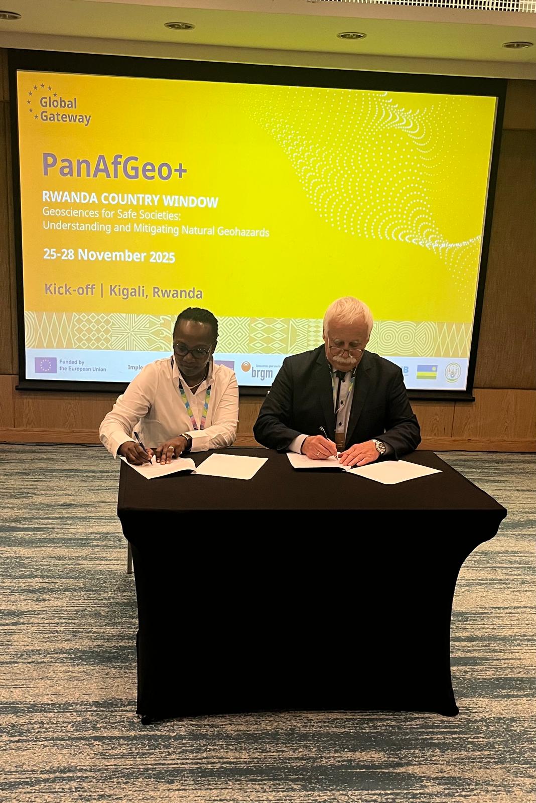 dwie osoby siedzące za stołem i podpisujące umowę