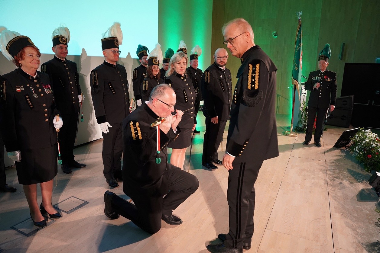 mężczyzna w mundurze górniczym klęczy na ziemi