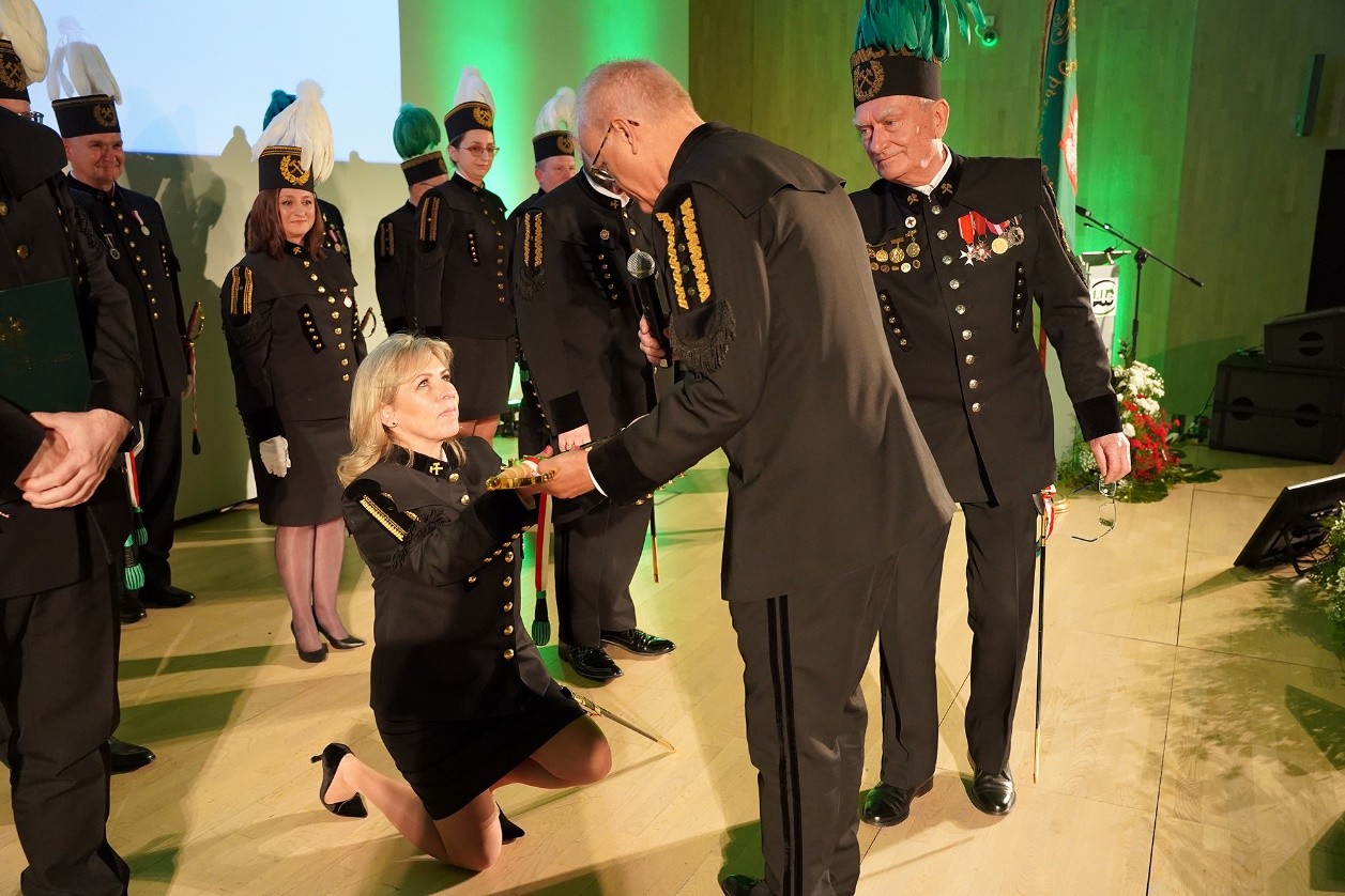 kobieta w mundurze górniczym klęczy na ziemi