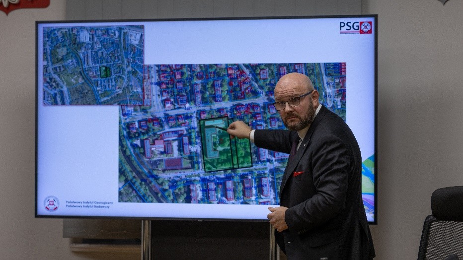 mężczyzna przemawia do siedzącej w pomieszczeniu publiczności