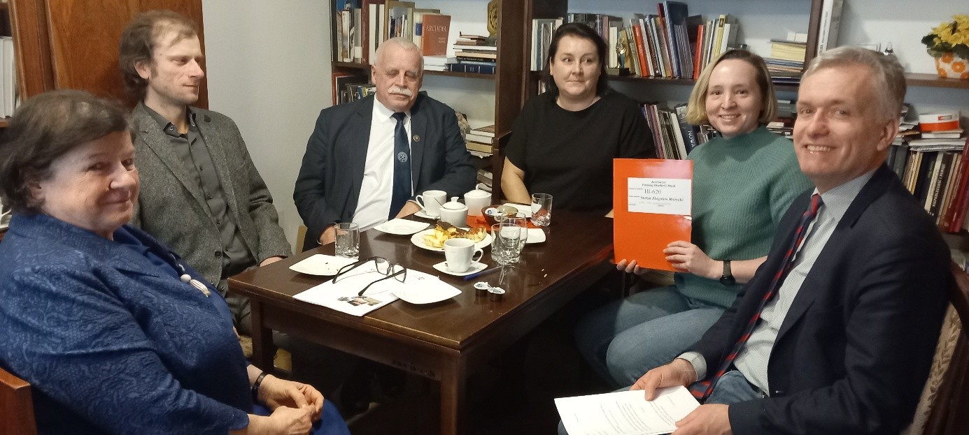 kilka osób siedzących za stołem w pokoju