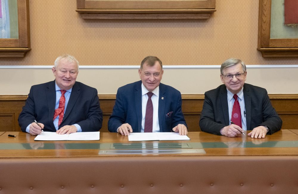 trzech mężczyzn pozuje do zdjęcia 