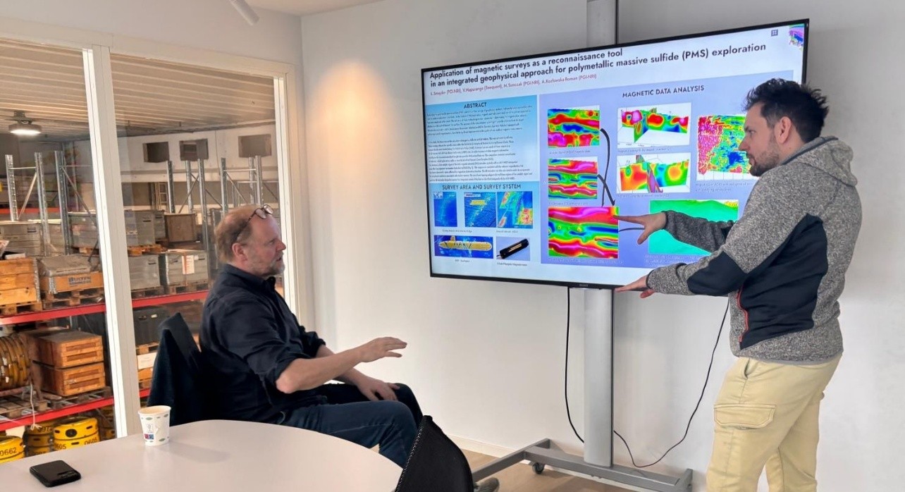 mężczyzna tłumaczy uczestnikom kwestie na ekranie