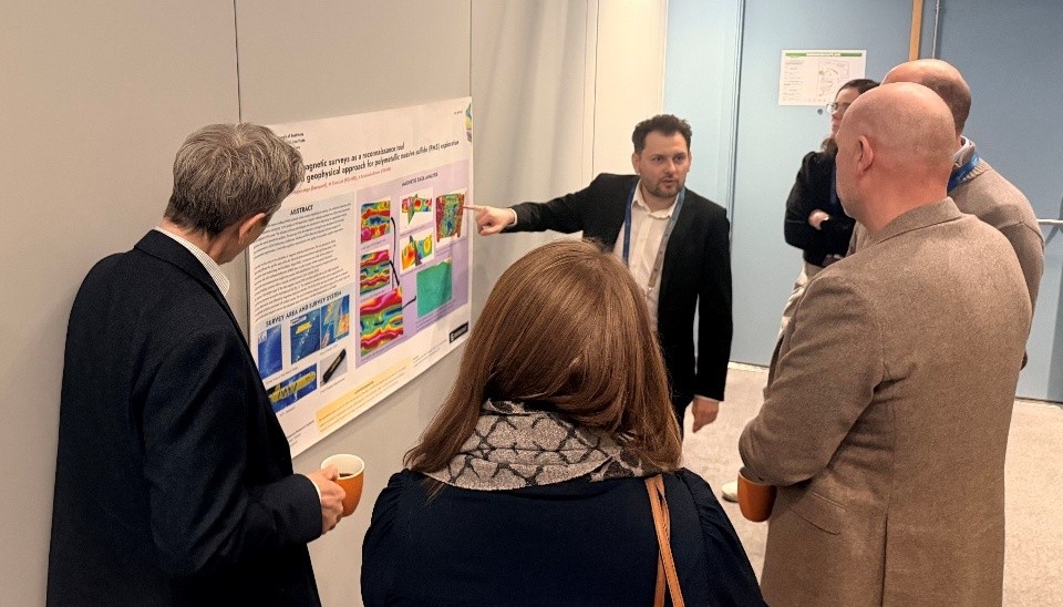 mężczyzna tłumaczy uczestnikom kwestie na posterze