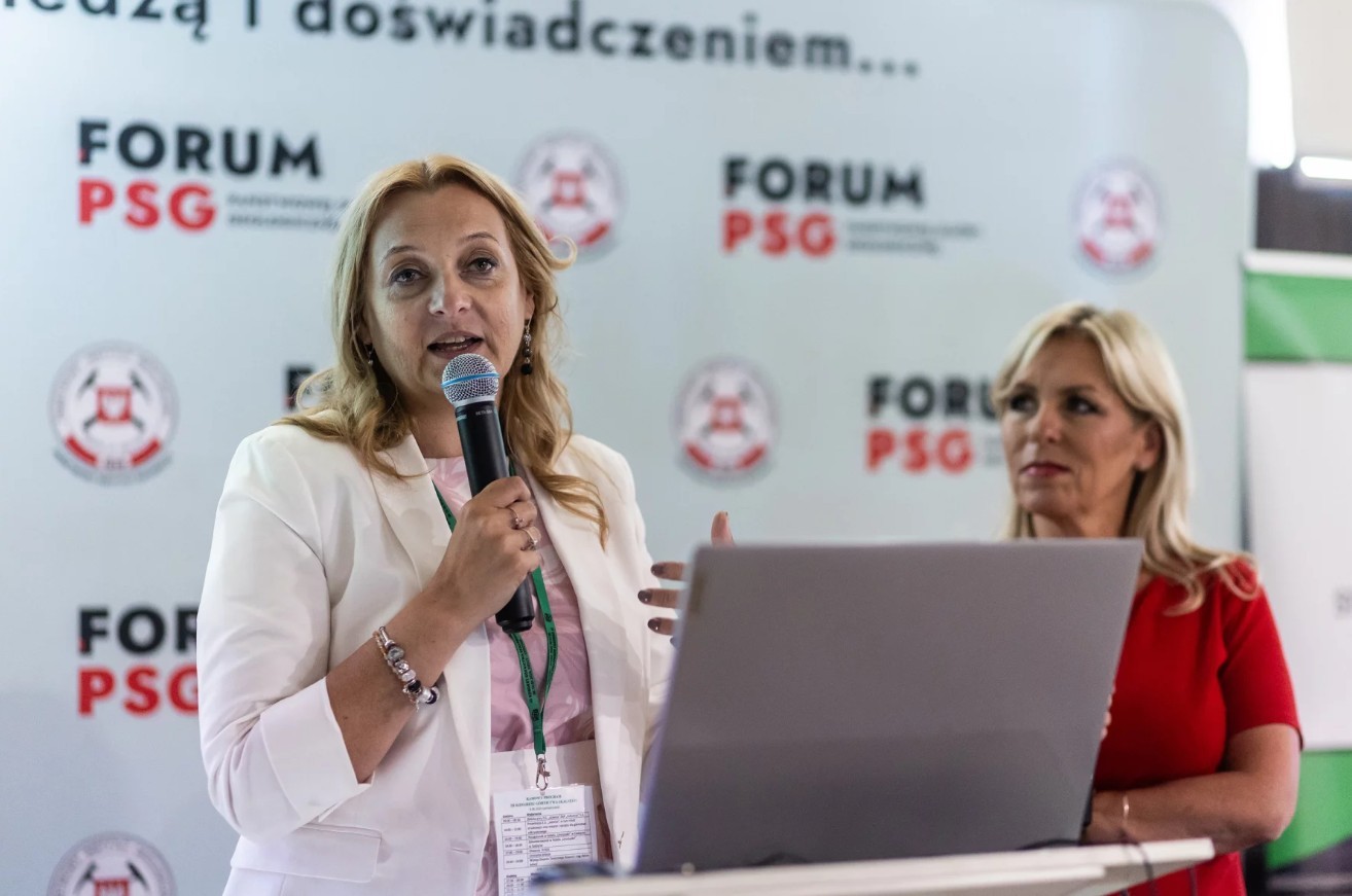 dwie kobiety stoją przy mównicy