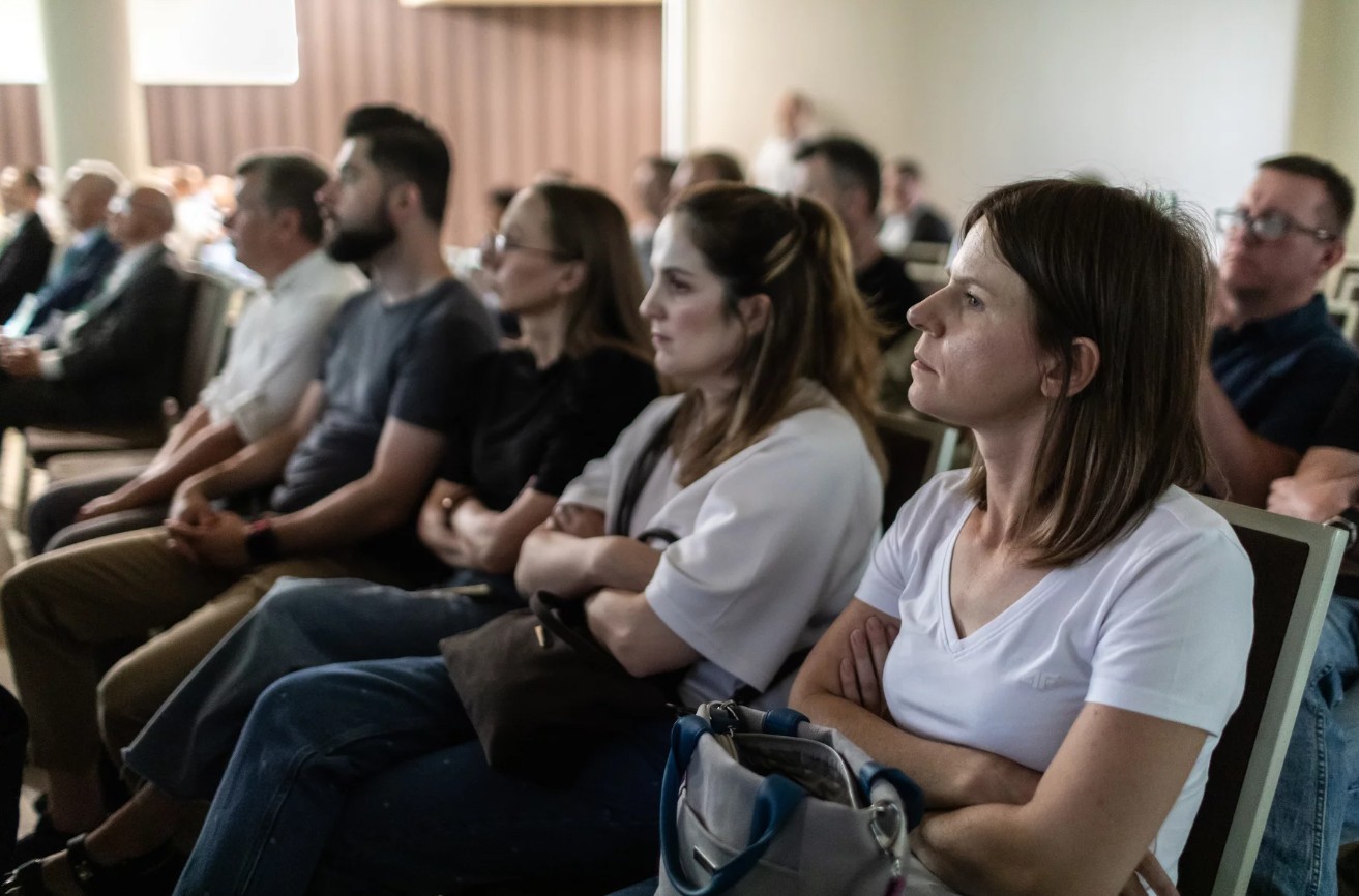 ludzie siedzący na sali konferencyjnej