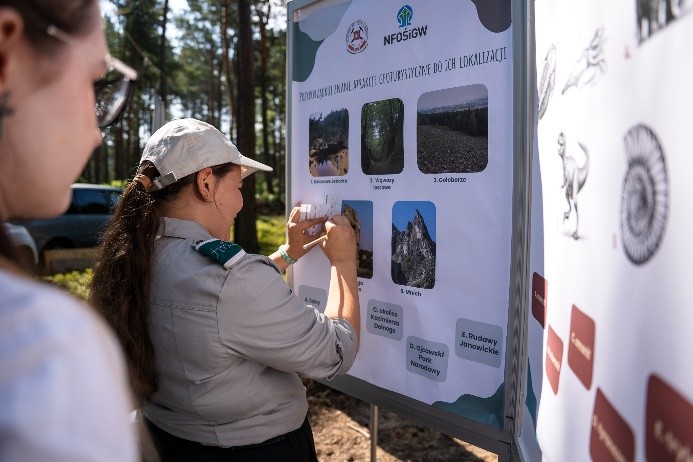 dzieci w mundurach harcerskich oglądają plansze edukacyjne